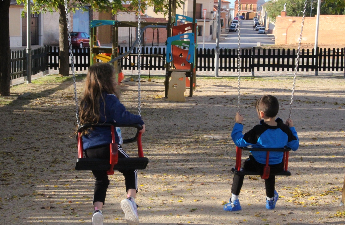 -Dos niños juegan con la valla al fondo